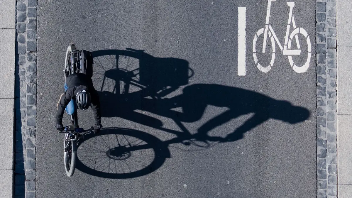 Ein bislang unbekannter Radfahrer hat am Freitag mit einer Fahrradkette auf eine Fußgängerin eingeschlagen und sie beleidigt. Die Polizei sucht jetzt nach Zeugen. (Symbolbild)
15.04.2019, Niedersachsen, Braunschweig: Eine Fahrradfahrerin fährt über eine Straße am Rathaus mit einer Markierung für Fahrräder. Foto: Julian Stratenschulte/dpa +++ dpa-Bildfunk +++
