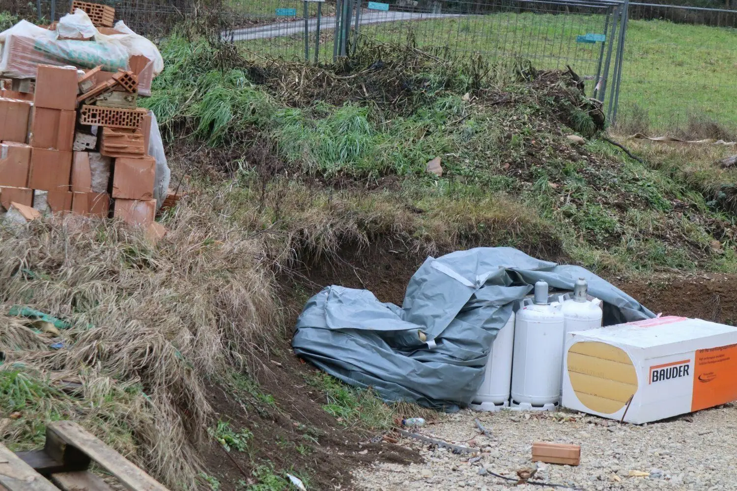 Reste von Baumaterial liegen achtlos herum. Frei zugänglich, weil der Bauzaun zur Straße hin beiseite geräumt wurde, stehen auch 19-Kilogramm-Propangasflaschen herum.⇥