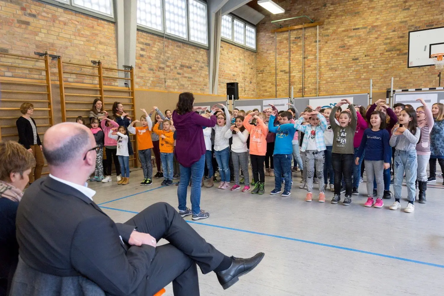 Die Grundschüler der Tegelberschule singen in der Turnhalle vor dem Spatenstich das Lied von den fröhlichen Handwerkern.