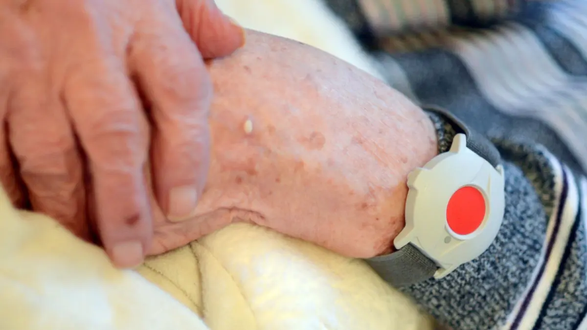 Eine pflegebedürftige Frau trägt den Hausnotruf am Handgelenk. Schon ein minimaler Druck oder eine Erschütterung lösen einen lebenswichtigen Notruf aus.
ARCHIV - Eine pflegebedürftige Frau trägt am 05.12.2013 in Potsdam einen Notknopf am Handgelenk. (zu dpa: «Falsche Reaktion nach Hausnotruf? Bundesgerichtshof verhandelt über Schmerzensgeld» vom 11.05.2017) Foto: Britta Pedersen/dpa-Zentralbild/dpa +++ dpa-Bildfunk +++