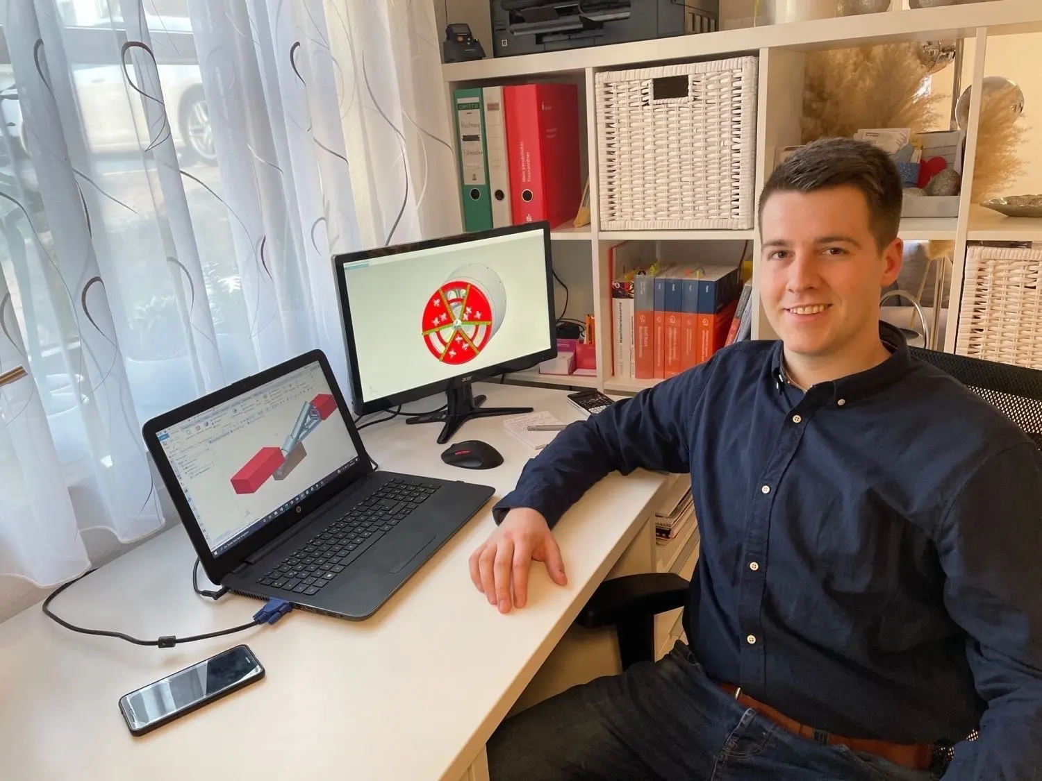 Kreativer Prozess im virtuellen Raum: Alexander Gröber an seinem Schreibtisch. Auf den Bildschirmen sind Animationen der Tunnelbohrmaschine zu sehen. ⇥