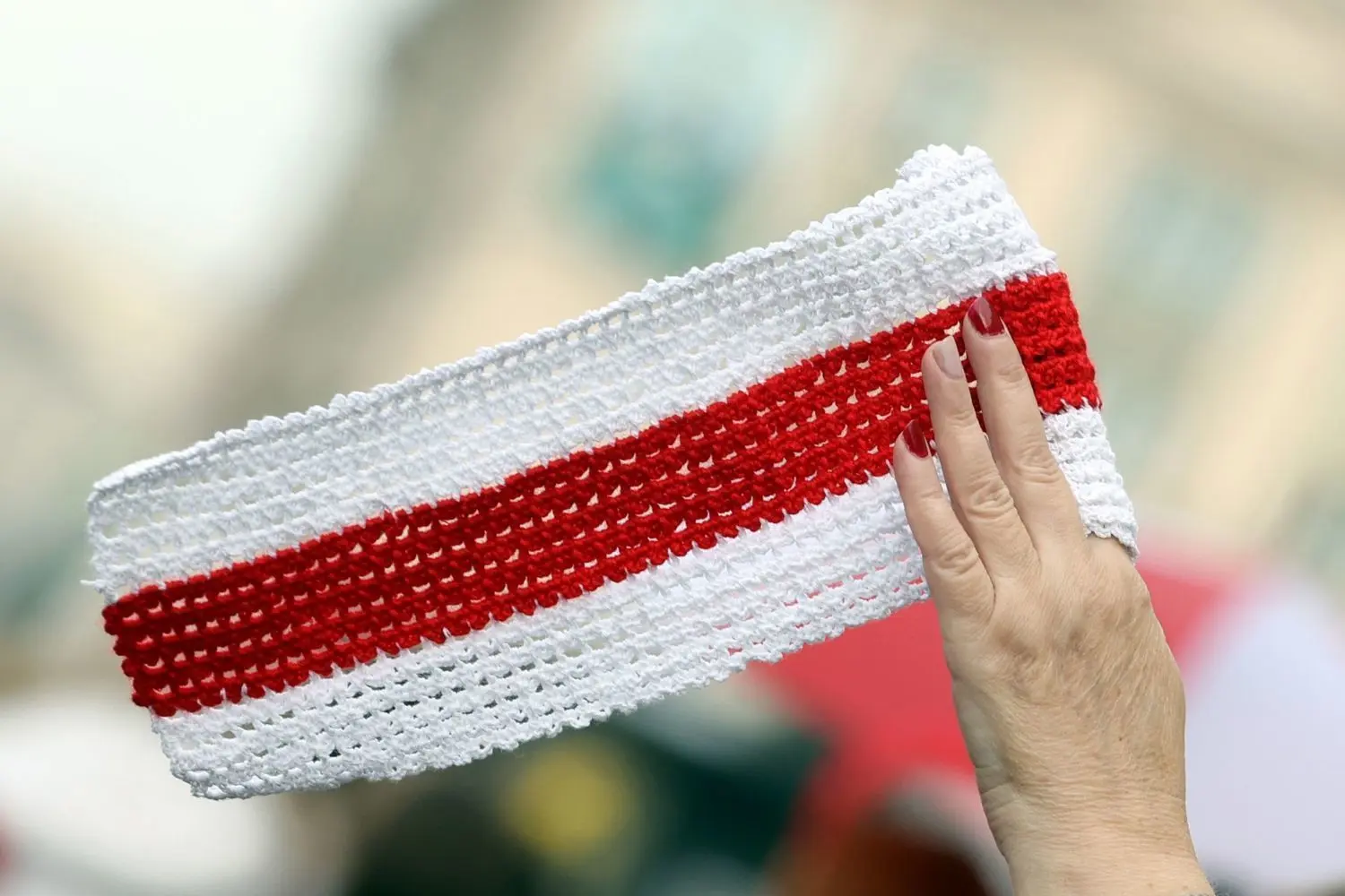 Zeichen des Protests: Eine Frau hält einen Teil der weißrussischen Flagge hoch.