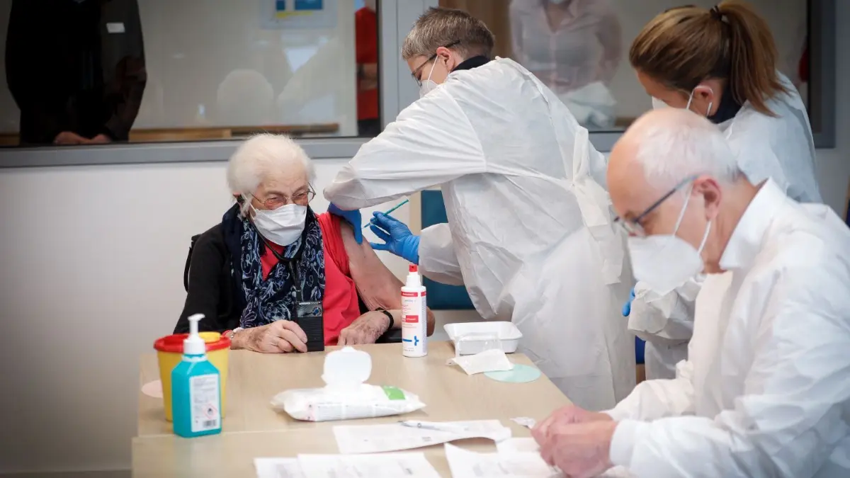 Die erste, die in Ulm gegen das Coronavirus geimpft wurde: Hedwig Grubbauer wird von Dr. Carola Rummel aus Biberach im Ulmer Pflegeheim Bethesda der Corona-Impfstoff gespritzt.
Erste Impfung im Innenhof des Bethesda-Seniorenzentrums
