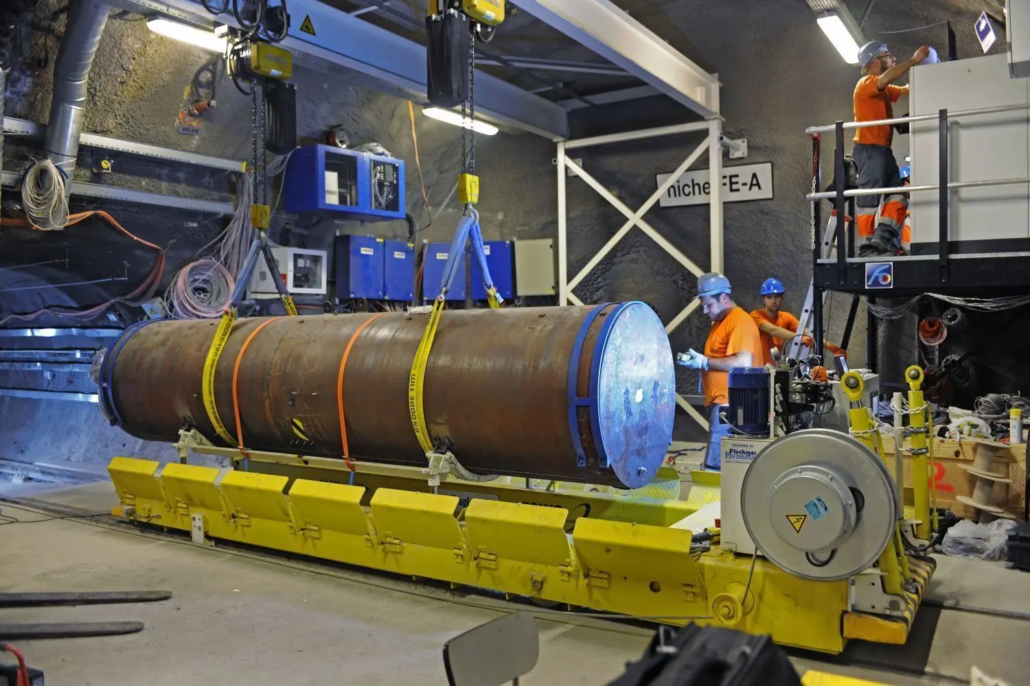 Vorbereitung auf ein wichtiges Experiment: Arbeiter bringen einen Atommüll-Behälter in Stellung, der im Versuchsstollen eingelagert werden soll.