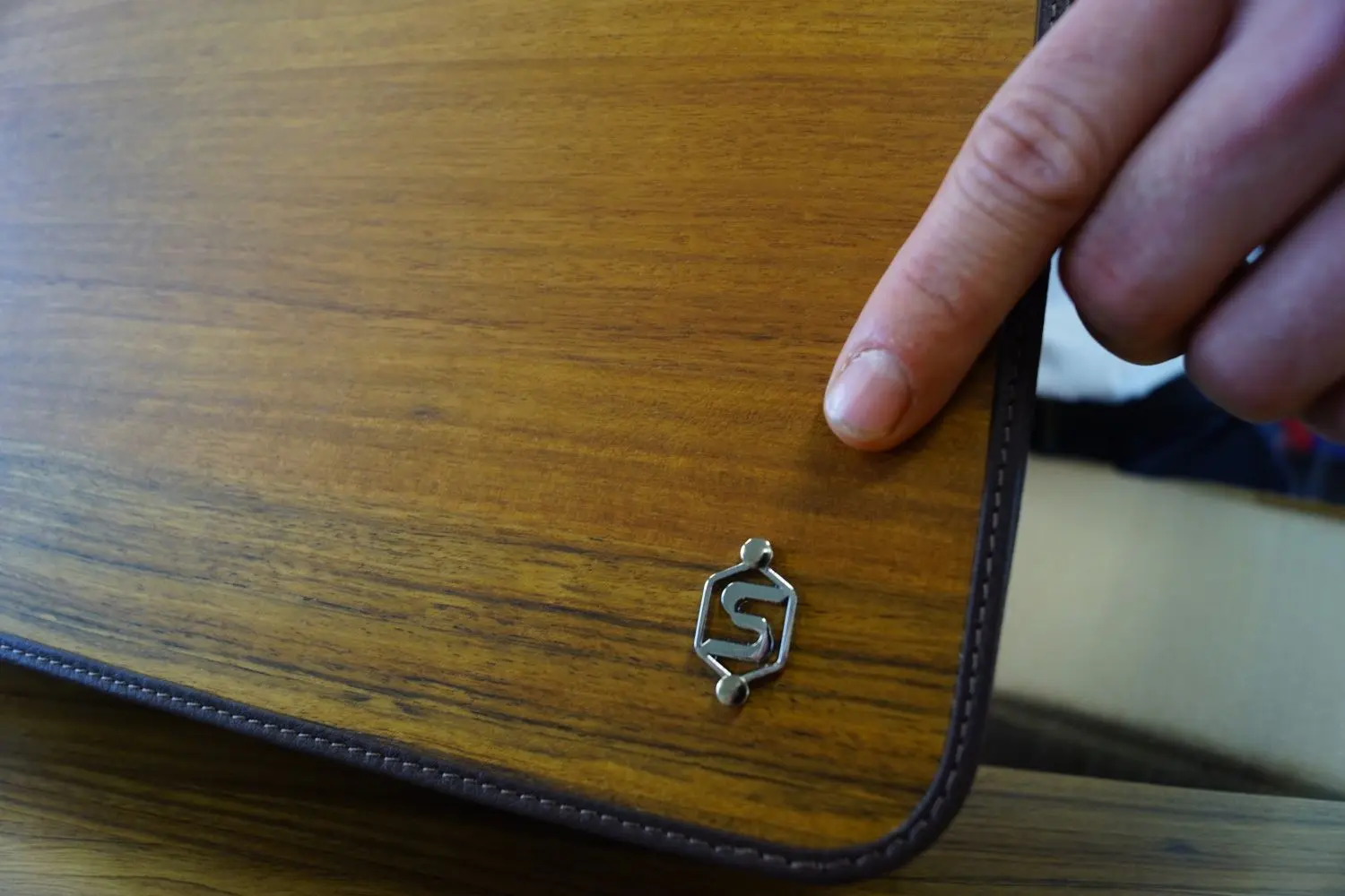 Aktentasche mit Holzfurnier mit dem Logo von Sebastian Sturm.⇥