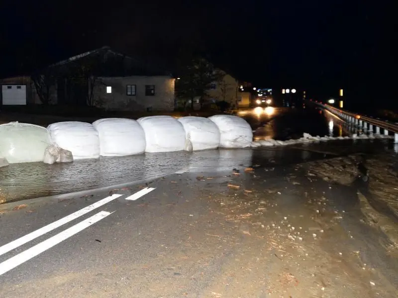 Eingepackte Heuballen und Sandsäcke liegen als Barriere gegen Wasser und Schlamm auf der Brenner-Bundesstraße. Auch die nahe gelegene Brennerautobahn musste gesperrt werden.