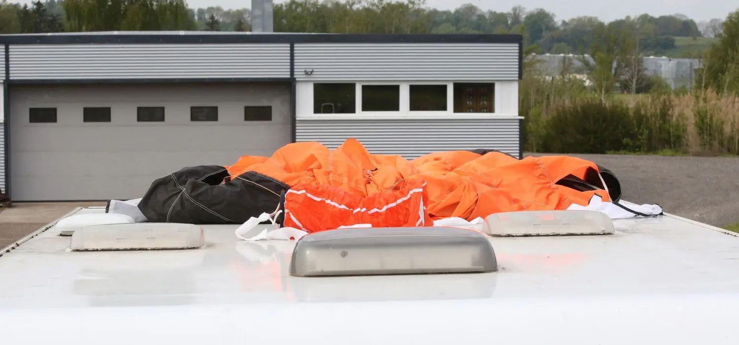 Der Fallschirm eines der Verunglückten auf dem Dach eines Wohnmobiles auf dem Parkplatz am Flugplatz.