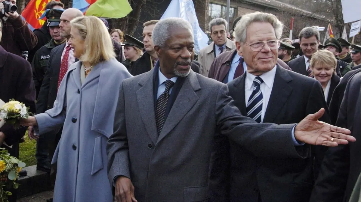 Kofi Annan (M), der Generalsekretär der Vereinten Nationen, läuft am Freitag (12.12.2003) nach seiner Weltethosrede in der Eberhard Karls Universität in Tübingen zur Universitätsbibliothek in Tübingen. Begleitet wird er von Hans Küng (r), dem Leiter der Weltethos-Stiftung. Links Nane Annan, die Ehefrau von Kofi Annan. Auf Einladung von Hans Küng hielt Kofi Annan in Tübingen die Dritte Weltethosrede. Foto: Bernd Weißbrod dpa/lsw +++ dpa-Bildfunk +++