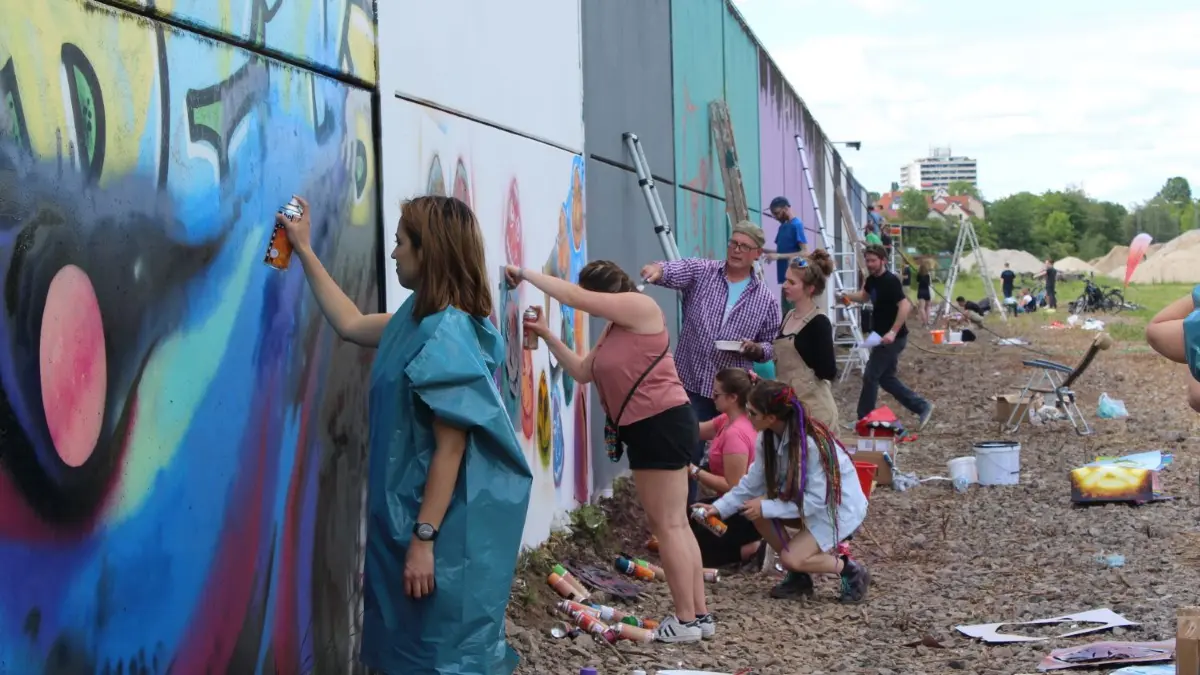 47 Graffiti-Künstler aus Reutlingen und den Partnerstädten verwandeln eine riesige Wand in ein farbenfrohes Kunstwerk.