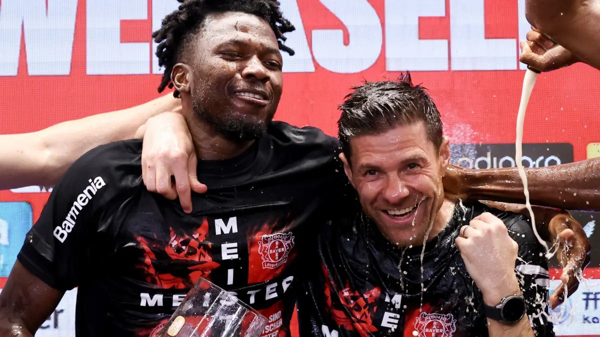 Bayer Leverkusen — Werder Bremen: 14.04.2024, Nordrhein-Westfalen, Leverkusen: Fußball: Bundesliga, Bayer 04 Leverkusen - SV Werder Bremen, 29. Spieltag, BayArena. Leverkusens Trainer Xabi Alonso (r) wird bei der Pressekonferenz nach dem Spiel von seinen Spielern mit Bier übergossen. Links: Edmond Tapsoba. Leverkusen gewinnt die Deutsche Meisterschaft. WICHTIGER HINWEIS: Gemäß den Vorgaben der DFL Deutsche Fußball Liga bzw. des DFB Deutscher Fußball-Bund ist es untersagt, in dem Stadion und/oder vom Spiel angefertigte Fotoaufnahmen in Form von Sequenzbildern und/oder videoähnlichen Fotostrecken zu verwerten bzw. verwerten zu lassen. Foto: Rolf Vennenbernd/dpa +++ dpa-Bildfunk +++
