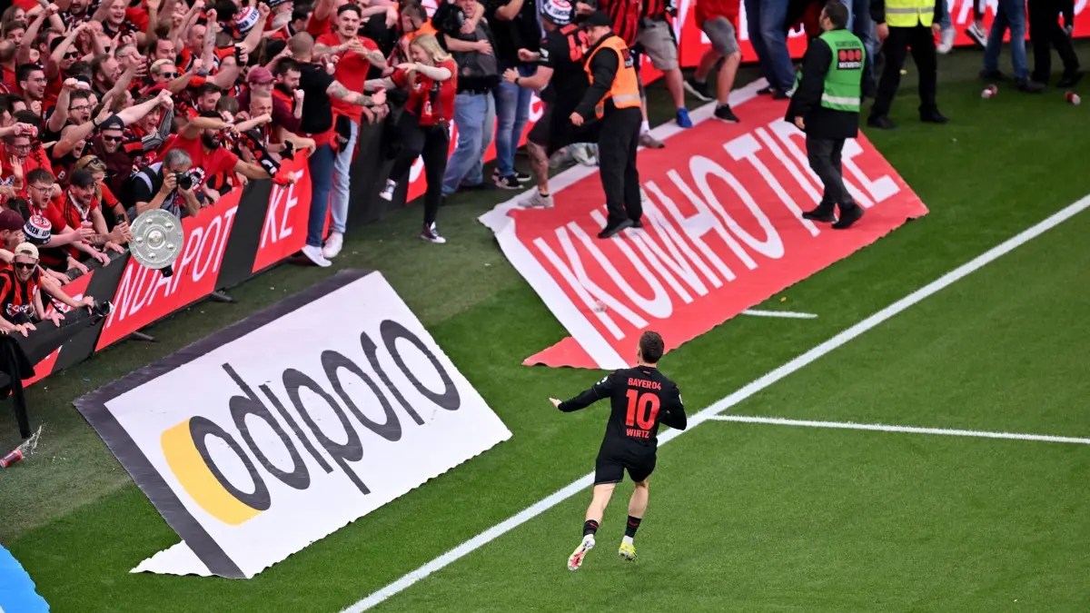 Bayer Leverkusen — Werder Bremen: 14.04.2024, Nordrhein-Westfalen, Leverkusen: Fußball: Bundesliga, Bayer 04 Leverkusen - SV Werder Bremen, 29. Spieltag, BayArena. Leverkusens Florian Wirtz dreht nach seinem Tor zum 4:0 jubelnd ab und beruhigt Fans und Sicherheitspersonal, die auf das Spielfeld laufen. WICHTIGER HINWEIS: Gemäß den Vorgaben der DFL Deutsche Fußball Liga bzw. des DFB Deutscher Fußball-Bund ist es untersagt, in dem Stadion und/oder vom Spiel angefertigte Fotoaufnahmen in Form von Sequenzbildern und/oder videoähnlichen Fotostrecken zu verwerten bzw. verwerten zu lassen. Foto: David Inderlied/dpa +++ dpa-Bildfunk +++