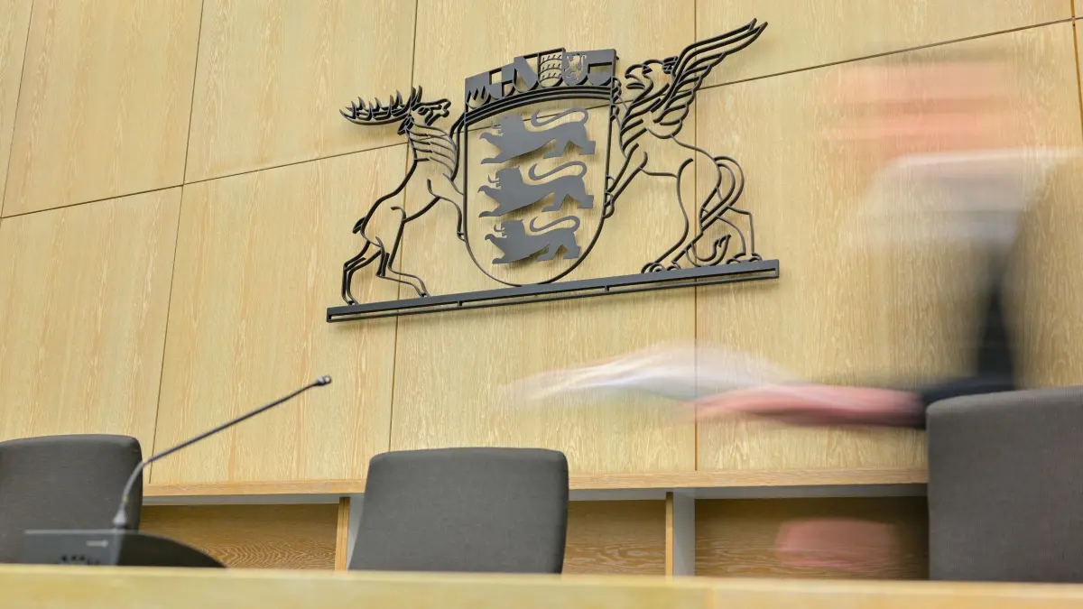 ARCHIV - 28.02.2019, Baden-Württemberg, Mannheim: Ein Richter geht in einem Sitzungssaal des Landgerichts an der Richterbank zu seinem Sitzplatz. Im Hintergrund hängt das Landeswappen von Baden-Württemberg. (Aufnahme mit langer Belichtungszeit) (zu dpa «Milch für kleine Tochter vergiftet? Mordprozess gegen Vater beginnt») Foto: Uwe Anspach/dpa +++ dpa-Bildfunk +++