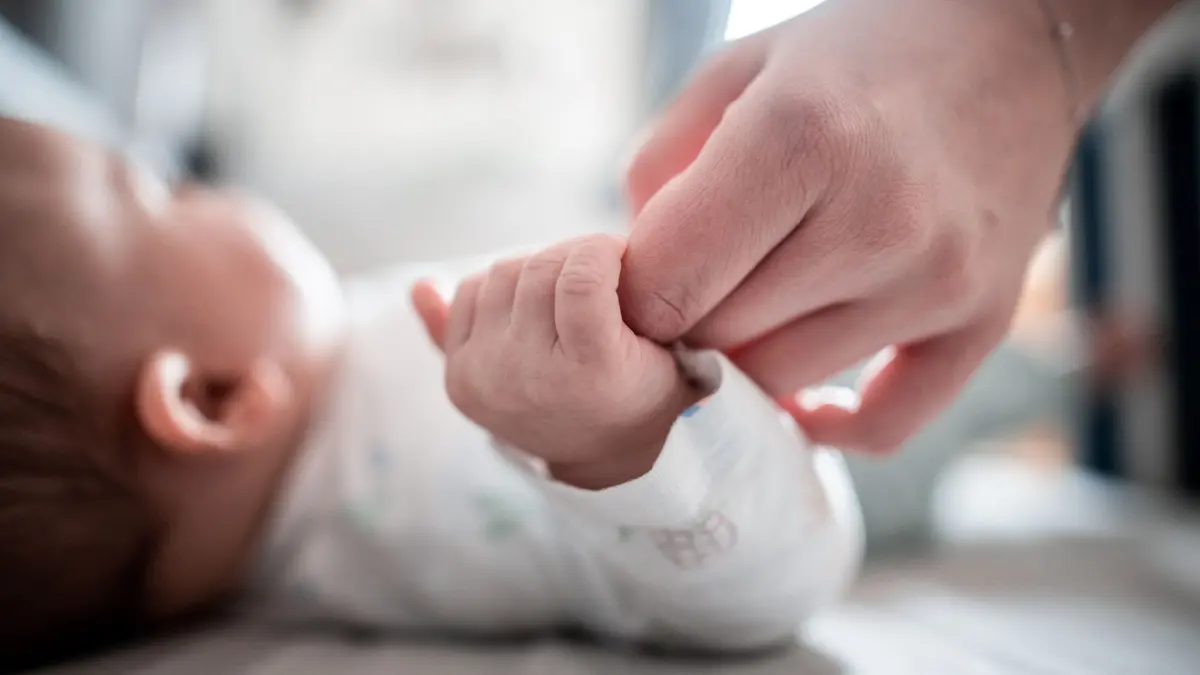 ARCHIV - 30.12.2019, Nordrhein-Westfalen, Oberhausen: Ein Baby klammert sich an den Finger seiner Mutter. (Zu dpa «Geburtenrate pro Frau in Bayern 2021 gestiegen») Foto: Fabian Strauch/dpa +++ dpa-Bildfunk +++