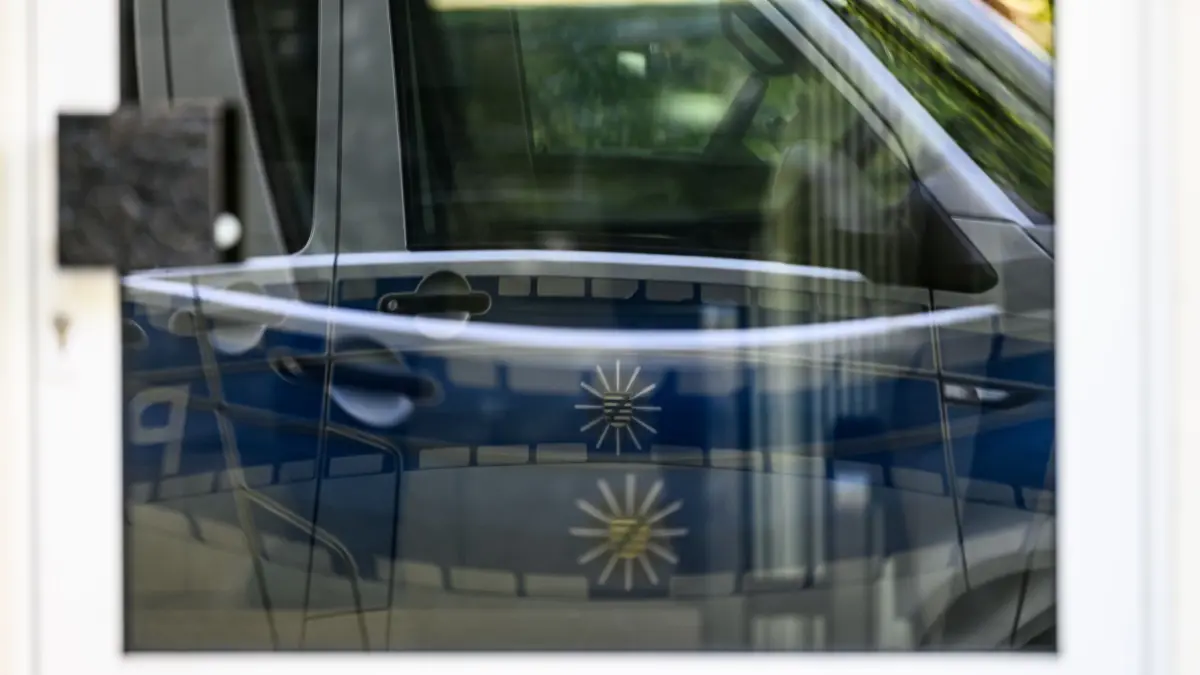 Mutmaßlicher China–Spion festgenommen: 23.04.2024, Sachsen, Dresden: Ein Polizeiauto steht vor einem Wohnhaus und spiegelt in der Eingangstür. Ein Mitarbeiter des deutschen Europaabgeordneten Krah ist in Dresden wegen des Verdachts der Spionage für China festgenommen worden. (zu dpa: «Verdacht China-Spionage: Mitarbeiter von AfD-Abgeordnetem festgenommen») Foto: Robert Michael/dpa +++ dpa-Bildfunk +++