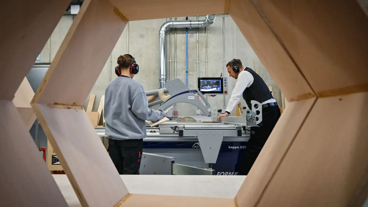 Zukunftstag in Brandenburg: 25.04.2024, Brandenburg, Cottbus: Hendrik Schulz, Zimmermann und Ausbildungsexperte der Berufsorientierung der Handwerkskammer Cottbus, zeigt einer 14-jährigen Schülerin den Umgang mit einer Kreissäge im CreativeOpenLab (COLab) an der Brandenburgische Technische Universität Cottbus-Senftenberg (BTU). Die Schülerin informierte sich beim Zukunftstag über die Möglichkeiten der Ausbildung zur Tischlerin. Am selben Tag hatten Unternehmen, Handwerksbetriebe, Hochschulen und viele andere Einrichtungen erneut die Türen zum «Zukunftstag für Mädchen und Jungen im Land Brandenburg» geöffnet. An diesem Tag konnten Jugendliche ab Klasse 7 erste praktische Einblicke in die Berufswelt erhalten und die Vielfalt der Ausbildungsberufe und Studienmöglichkeiten in Brandenburg kennenlernen, vor Ort oder digital im Netz. Foto: Patrick Pleul/dpa - Honorarfrei nur für Bezieher des Dienstes ZB-Funkregio Ost +++ ZB-FUNKREGIO OST +++
