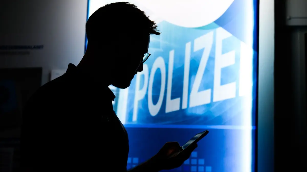 Cyberkriminalität — Landeskriminalamt Niedersachsen: PRODUKTION - 30.04.2024, Niedersachsen, Hannover: Eine Polizist steht mit einem Smartphone in der Präventionsstelle Cyberkriminalität im Landeskriminalamt Niedersachsen (gestellte Szene). Das LKA Niedersachsen setzt im Bereich Cyberkriminalität auf Prävention und informiert über Schwerpunkte der Internetkriminalität wie Identitätsdiebstahl und Hackerangriffe. (zu dpa: «Landeskriminalamt Niedersachsen warnt vor Cyberkriminalität») Foto: Julian Stratenschulte/dpa +++ dpa-Bildfunk +++