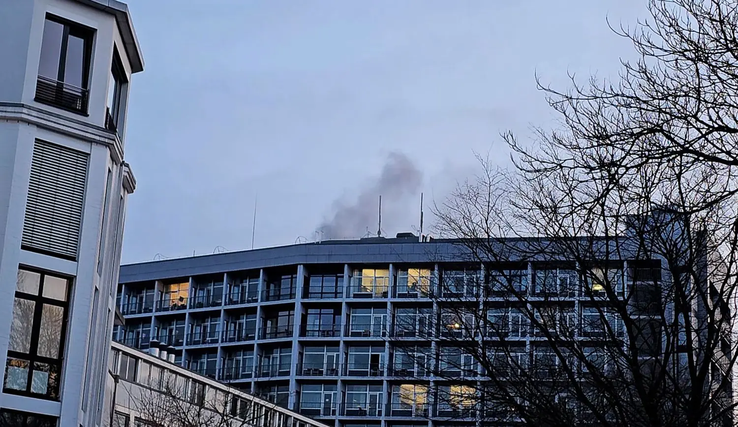 Rauch steigt über dem Dach einer Aachener Klinik auf. In der Klinik, in der sich am Montag eine 65-jährige Frau verschanzt hat, ist nach Polizeierkenntnissen bis zum Abend niemand verletzt worden.