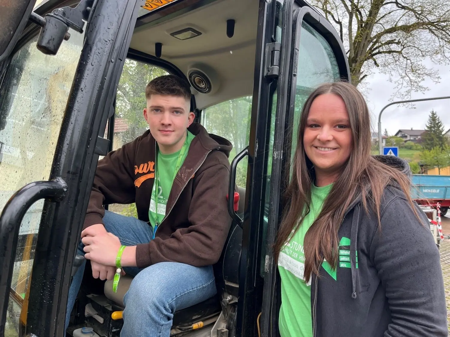 Luis Klingler (17) und Melanie Austen (31) von der KjG Westerstetten in einem Bagger vor dem Gemeindehaus St. Joseph. Sie bauten mit ihrer Gruppe den Garten um.