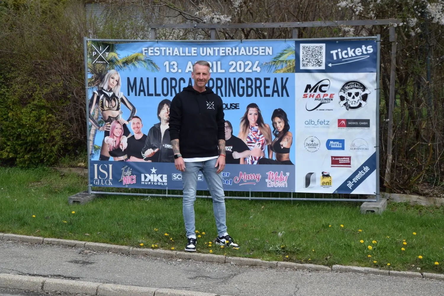 Peter Rist vor dem Banner beim Bahnhof in Kohlstetten. Der Party-Macher aus Engstingen erwartet ein volles Haus bei seinem Event „Mallorca Springbreak“, das am Samstag, 13. April, in der Festhalle in Unterhausen über die Bühne geht. ⇥