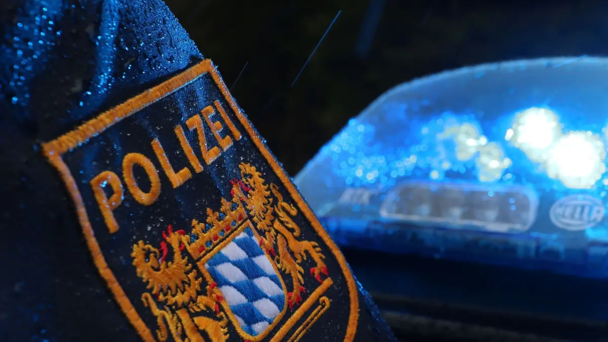 Kein Ermittlungsverfahren nach tödlichem Schuss durch Polizisten: ARCHIV - 15.03.2019, Bayern, Kempten: Ein Polizist steht im Regen vor einem Streifenwagen, dessen Blaulicht aktiviert ist. (zu dpa: «Polizist erschießt auffälligen Mann - Kein Ermittlungsverfahren») Foto: Karl-Josef Hildenbrand/dpa +++ dpa-Bildfunk +++