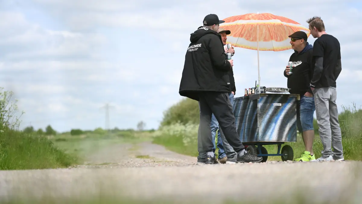 An einem Bollerwagen mit Sonnenschirm steht eine Gruppe Männer und feiert den Vatertag 2023. Christi Himmelfahrt ist ein kirchlicher Feiertag, der am 40. Tag nach Ostern begangen wird. Außerhalb der Kirchen erhielt Himmelfahrt den Beinamen «Vatertag». Er wird traditionell mit Herrenpartien und Trinkgelagen gefeiert - in den letzten Jahren wird er auch im Familien- und Familienfreundeskreis begangen. +++ dpa-Bildfunk +++