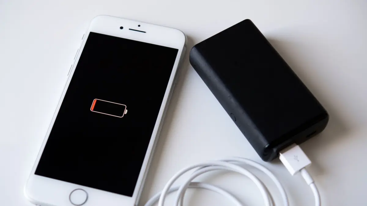 Ein Smartphone wird mit einer Powerbank aufgeladen: ILLUSTRATION - Akku schon wieder leer? Das muss nicht unbedingt an im Hintergrund laufenden Apps liegen. (zu dpa: «Mythen-Check: Apps manuell schließen, um Akku zu sparen?») Foto: Catherine Waibel/dpa-mag - Honorarfrei nur für Bezieher des Dienstes dpa-Magazin +++ dpa-Magazin +++