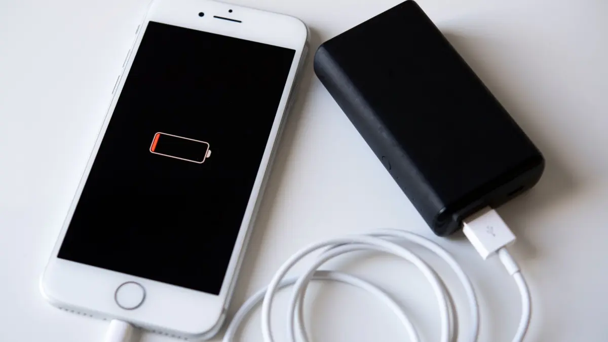 Ein Smartphone wird mit einer Powerbank aufgeladen: ILLUSTRATION - Akku schon wieder leer? Das muss nicht unbedingt an im Hintergrund laufenden Apps liegen. (zu dpa: «Mythen-Check: Apps manuell schließen, um Akku zu sparen?») Foto: Catherine Waibel/dpa-mag - Honorarfrei nur für Bezieher des Dienstes dpa-Magazin +++ dpa-Magazin +++
