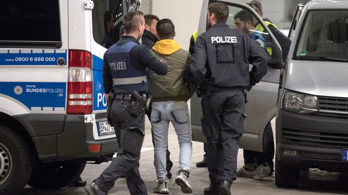 Abschiebung: ARCHIV - 04.12.2018, Hessen, Frankfurt/Main: Hand und Fußfesseln trägt ein junger Mann aus Afghanistan, den Polizisten zur Abschiebung zum Flughafen bringen. (zu dpa: «Entwurf für Landesgesetz zu Abschiebungen steht») Foto: Boris Roessler/dpa +++ dpa-Bildfunk +++