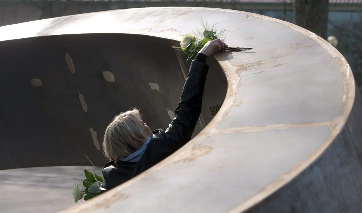 Trauernde am Mahnmal „Gebrochener Ring“ für die Opfer des Amoklaufs. ⇥