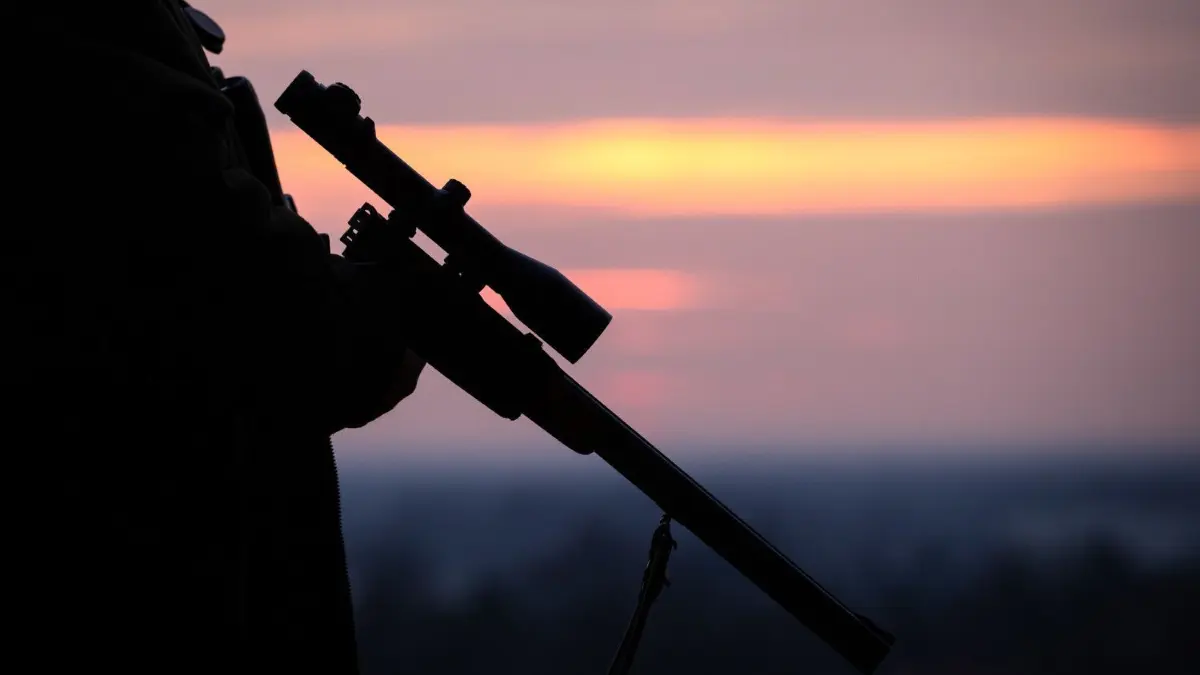 Warten auf Waschbär und Co: Ein Jäger in der Abenddämmerung.
ARCHIV - 20.02.2019, Bielefeld: Ein Jäger hält sein Gewehr in der Abenddämmerung. (zu dpa: «Saar-Jäger erlegen halb so viele Wildschweine») Foto: Friso Gentsch/dpa +++ dpa-Bildfunk +++