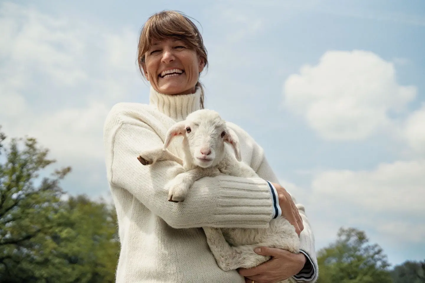 Geschäftsführerin Katja Beibl mit dem Markenmaskottchen Finchen – ein Merino-Schaf – auf dem Arm. ⇥