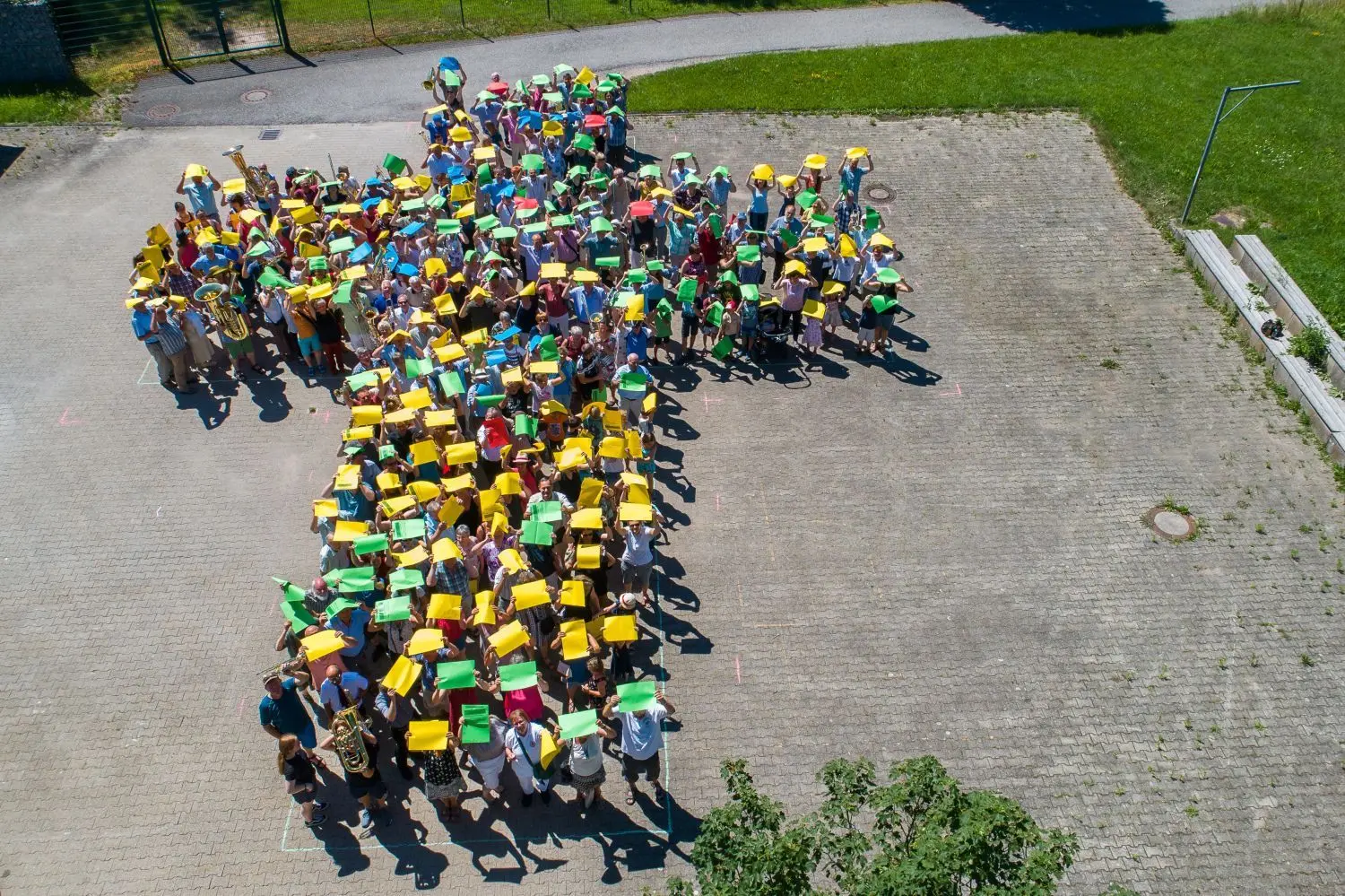 Ein „Menschenkreuz“ bildeten die Teilnehmer des Kirchenbezirkstages neben der Zeltkirche. Rechts: Rund 500 Besucher wohnten dem Eröffnungsgottesdienst bei, der mit einem humorvollen Anspiel eingeleitet wurde (unten). ⇥
