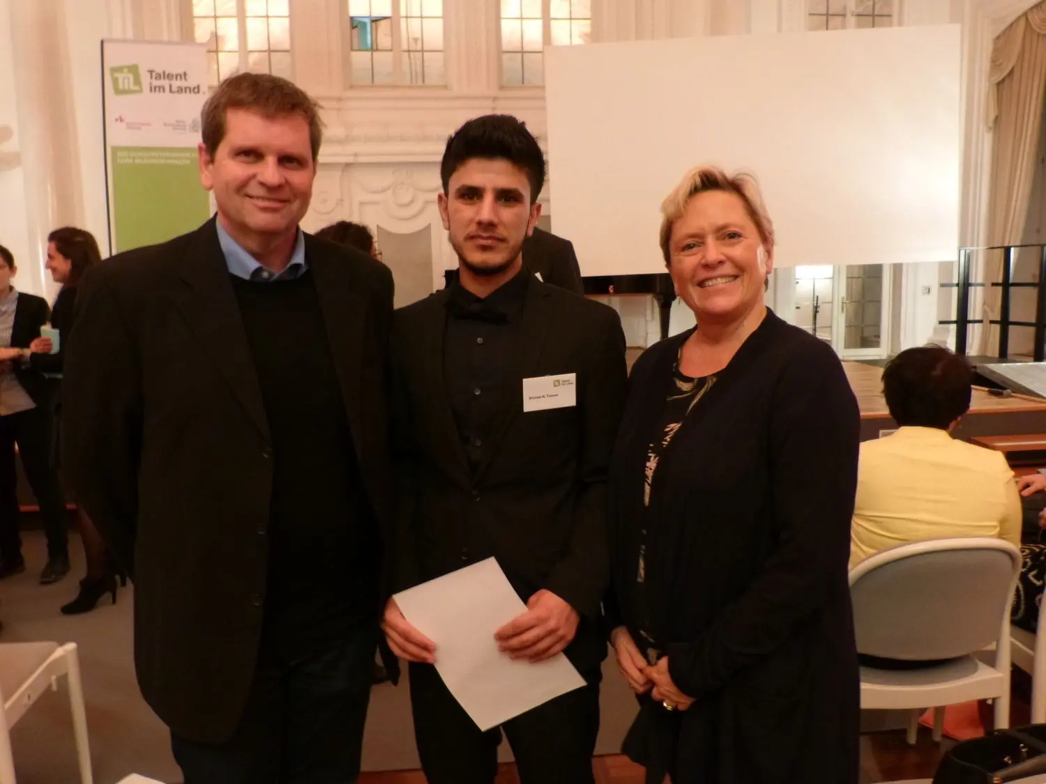 Ahmed Al Toama (Mitte) wurde in das Programm „Talent im Land“ aufgenommen. Kultusministerin Eisenmann überreicht die Urkunde, Schulleiter Dr. Rainer Wetzler begleitete Al Toama.