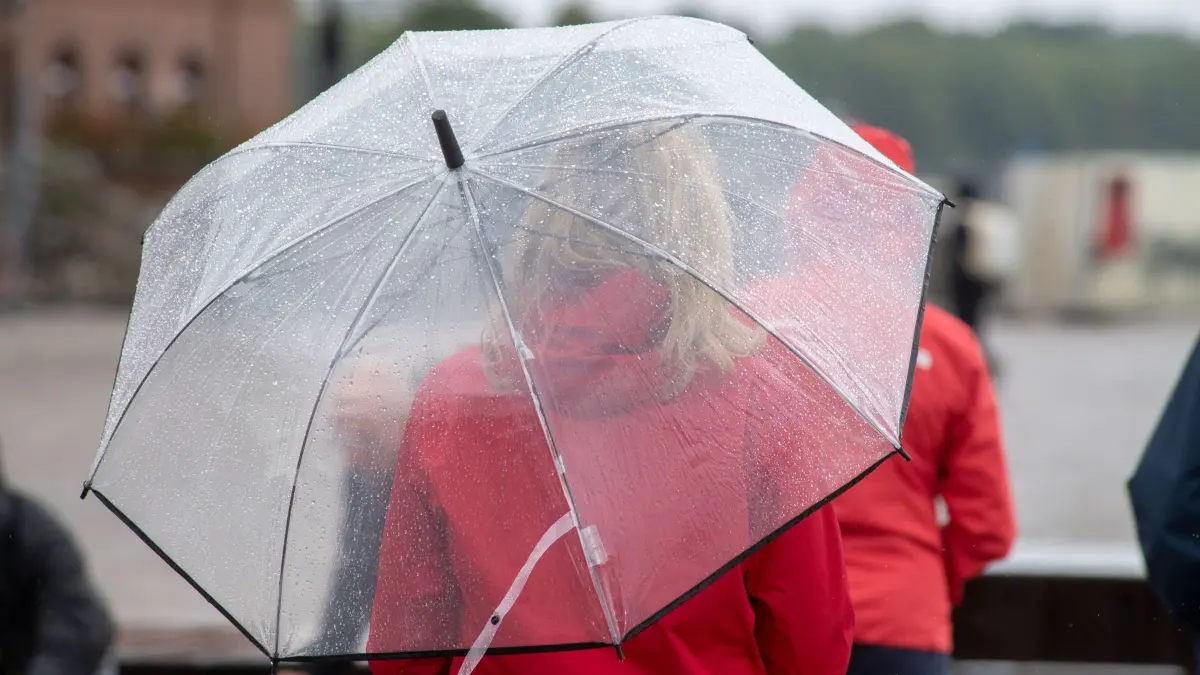 Graues Wetter: ARCHIV - 07.08.2023, Mecklenburg-Vorpommern, Stralsund: Eine Frau mit einem Regenschirm. (zu dpa: «Rheinland-Pfalz und Saarland erwarten Sturm und Regen») Foto: Stefan Sauer/dpa +++ dpa-Bildfunk +++