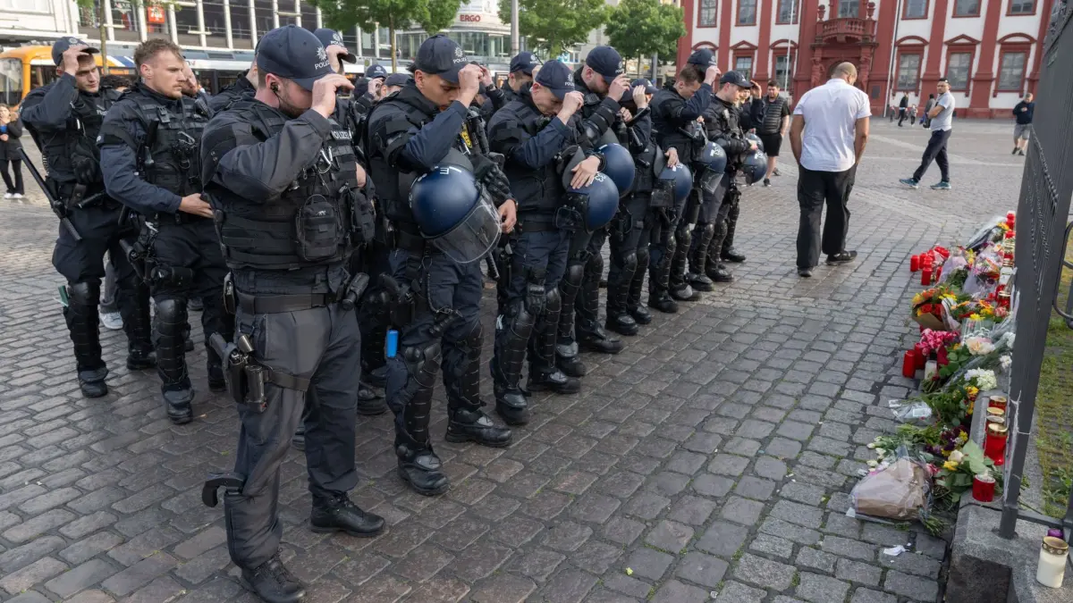 Trauer um ermordeten Polizisten in Mannheim: 02.06.2024, Baden-Württemberg, Mannheim: Minuten nach dem Bekanntwerden seines Todes trauern Polizisten auf dem Marktplatz in Mannheim um ihren getöteten Kollegen. Der Polizist war hier von einem Mann mit einem Messer niedergestochen und lebensgefährlich verletzt worden. Foto: Boris Roessler/dpa +++ dpa-Bildfunk +++