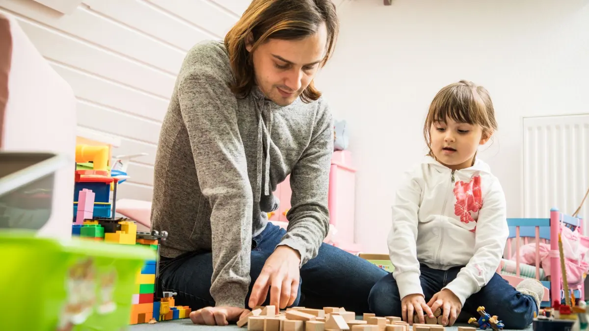 Vater spielt mit seiner Tochter: ILLUSTRATION - Auch wenn viele Arbeitgeber Flexibilität betonen, hat ein Großteil der Eltern im Job schon negatives Feedback erfahren, wenn sie sich für die Kinderbetreuung freinehmen mussten. (zu dpa: «Umfrage: Kinderbetreuung bringt Eltern im Job oft Nachteile») Foto: Christin Klose/dpa-mag - Honorarfrei nur für Bezieher des Dienstes dpa-Magazin +++ dpa-Magazin +++
