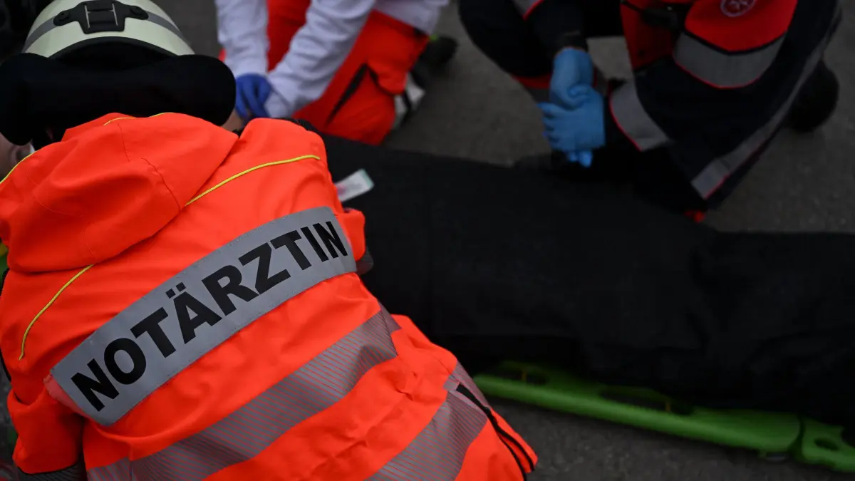 An emergency doctor takes care of a victim during a rescue drill of the emergency services in Munich, southern Germany, on October 8, 2022. - A total of 320 participants took part in the exercise, including firefighters, paramedics, emergency doctors and victim actors. (Photo by Christof STACHE / AFP)