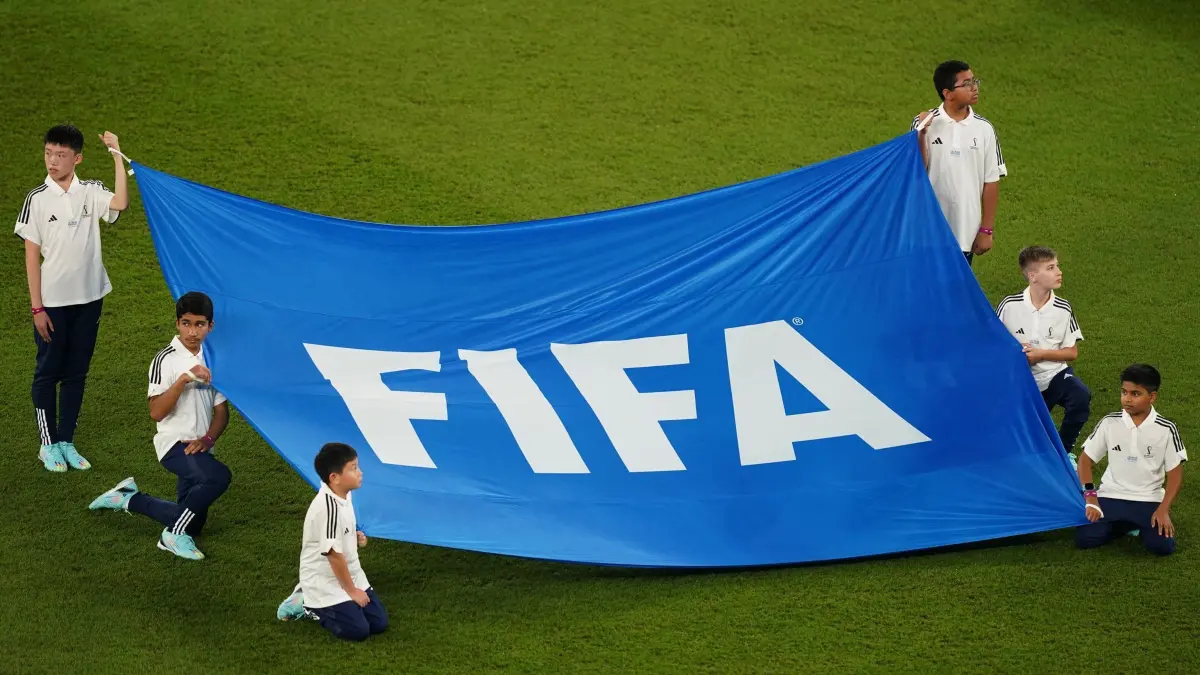 FIFA–Banner: ACHTUNG: SPERRFRIST 6. JUNI 01:01 UHR. FREI FÜR DONNERSTAGSAUSGABEN - ARCHIV - 26.11.2022, Katar, Doha: Fußball, WM, Frankreich - Dänemark, Vorrunde, Gruppe D, Spieltag 2, Stadion 974, Kinder halten ein Banner mit der Aufschrift "FIFA". Amnesty International gibt der FIFA Empfehlungen für die Weltmeisterschaften 2030 und 2034. (zu dpa: «WM 2030 und 2034: Forderungen von Menschenrechtlern an FIFA») Foto: Mike Egerton/PA Wire/dpa +++ dpa-Bildfunk +++