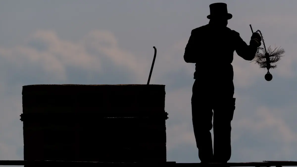 Schornsteinfeger: ARCHIV - 15.05.2020, Sachsen, Dresden: Ein Schornsteinfeger läuft mit seinem Kaminkehrerwerkzeug auf einem Dach entlang. (zu dpa: «Höchststand bei Schornsteinfegern - kein Mangel in Niedersachsen») Foto: Robert Michael/dpa-Zentralbild/dpa +++ dpa-Bildfunk +++