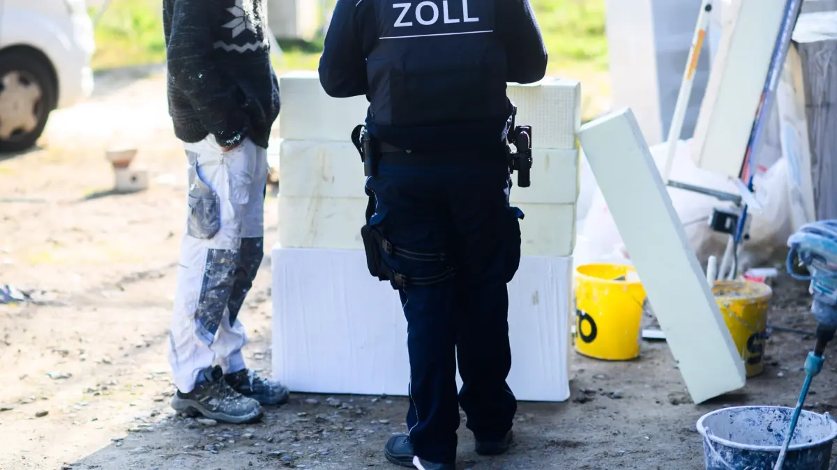 Prozess zu nicht gezahlten Löhnen: ARCHIV - 23.04.2024, Niedersachsen, Garbsen: Ein Zollbeamter (r) steht mit einem Bauarbeiter bei einer Kontrolle von Schwarzarbeit in einem Neubaugebiet in der Region Hannover. (zu dpa: «Landgericht Bielefeld verhandelt Millionen-Betrug im Baugewerbe»). (zu dpa: «Landgericht Bielefeld verhandelt Millionen-Betrug im Baugewerbe») Foto: Julian Stratenschulte/dpa +++ dpa-Bildfunk +++