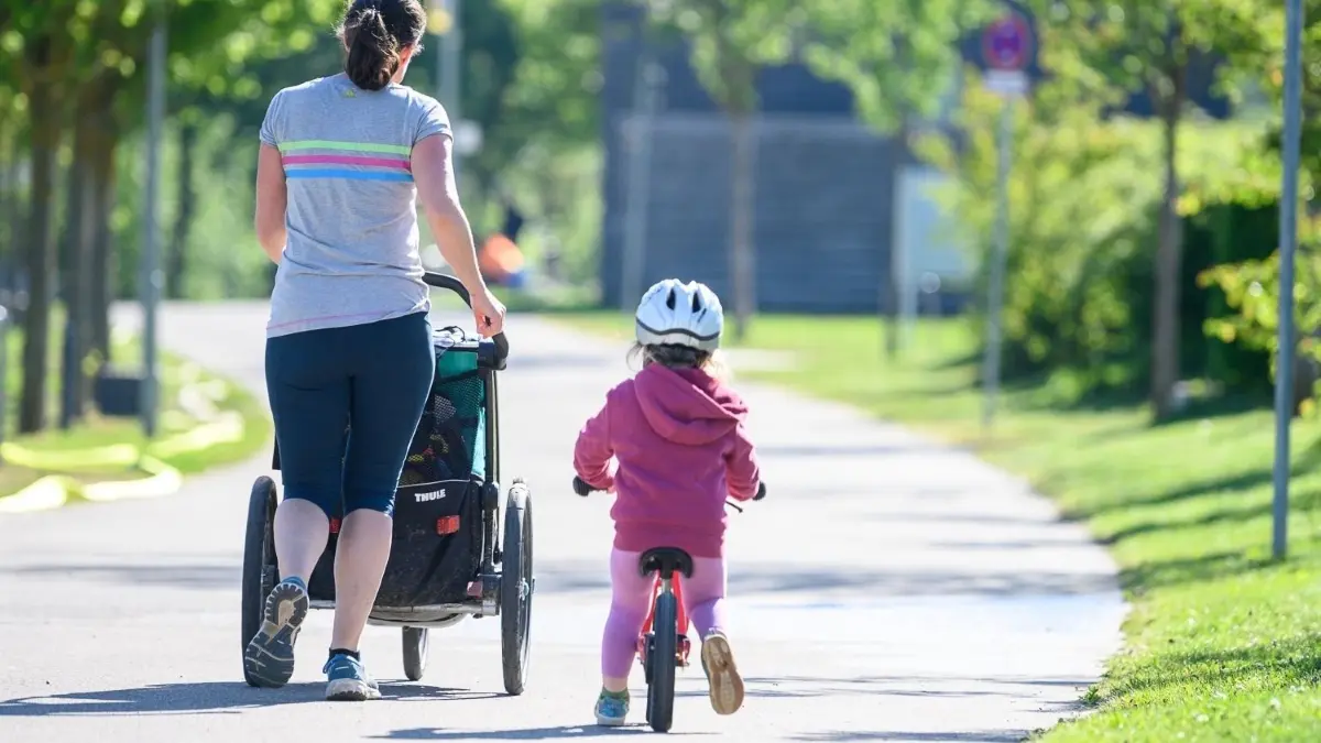 Elternschaft befördert die Ungleichheit am Arbeitsplatz, mit langfristigen Folgen für Frauen. Eine Ursache, die das befördert, ist das Ehegattensplitting.
Eine Frau joggt mit ihrer Tochter, die eigentlich in der Kita sein sollte, auf einem Weg. (zu dpa: «Regierung stellt Studie zu Kindern und Coronavirus vor») +++ dpa-Bildfunk +++