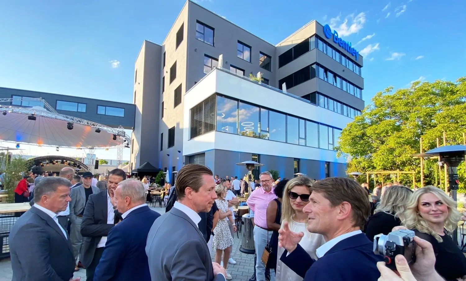 CEO Sebastian Büchert im Gespräch mit den Gastrednern. Im Hintergrund die Attraktion des Abends, der Neubau.⇥