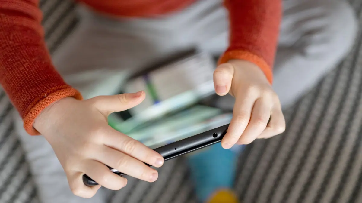 Medienkonsum bei Kindern: ILLUSTRATION - 16.01.2023, Berlin: Ein Kleinkind sitzt auf einem Sofa und hält ein Tablet in den Händen. (zu dpa: «Studie: Mehr Kleinkinder haben Zugang zu digitalen Geräten») Foto: Monika Skolimowska/dpa +++ dpa-Bildfunk +++