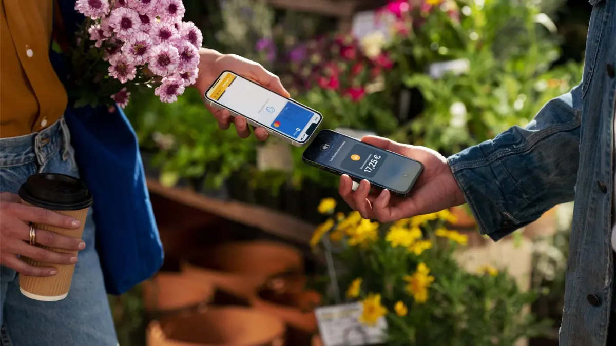 Apple — Tap to Pay: HANDOUT - 24.06.2024, ---, --: Ein von Apple verbreitetes, undatiertes Handout zeigt, wie eine Person in einem Blumenladen ein iPhone mit der Funktion Tap to Pay zur Annahme von Zahlungen benutzt. Foto: -/Apple/dpa - ACHTUNG: Nur zur redaktionellen Verwendung im Zusammenhang mit der aktuellen Berichterstattung und nur mit vollständiger Nennung des vorstehenden Credits +++ dpa-Bildfunk +++