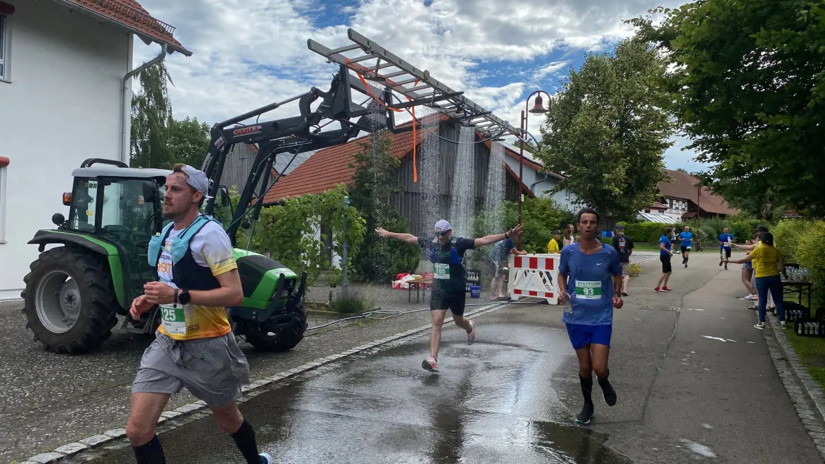 An der ersten Wechselstation in Oberspeltach bekommen die Läuferinnen und Läufer nicht nur Getränke und Obst, sondern auch eine kalte Dusche.