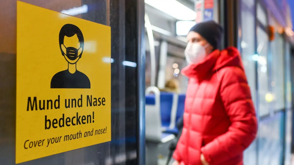 Corona-Pandemie in Deutschland: ARCHIV - 18.01.2021, Bayern, München: Eine Frau steigt mit FFP2-Maske in eine Trambahn ein. (zu dpa: «AfD für Rückzahlung von Corona-Bußgeldern») Foto: Tobias Hase/dpa +++ dpa-Bildfunk +++
