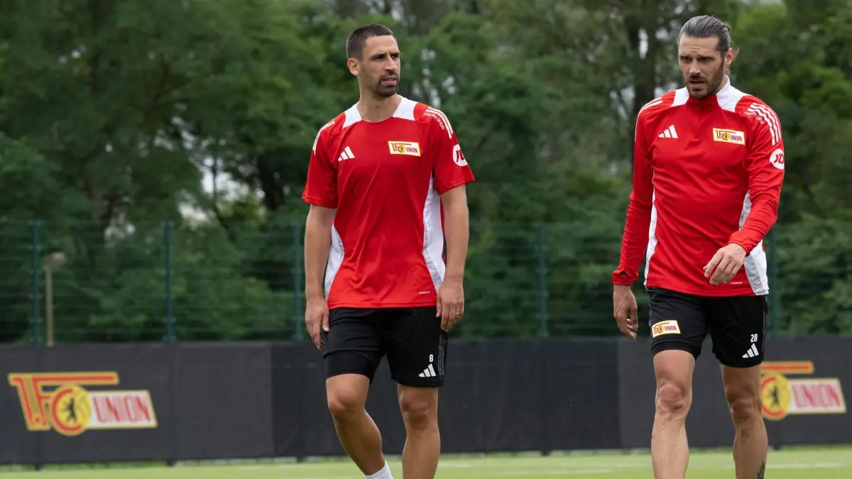 Trainingsauftakt 1. FC Union Berlin: 03.07.2024, Berlin: Fußball: Bundesliga, 1. FC Union Berlin, Unions Rani Khedira (l) und Christopher Trimmel (r) gehen beim Trainingsauftakt der Saison 2024/2025 über den Platz. Khedira war der erste Berliner Torschütze im ersten Test. (zu dpa: «Erstes Testspiel: 1. FC Union siegt bei Chemie Leipzig») Foto: Soeren Stache/dpa +++ dpa-Bildfunk +++