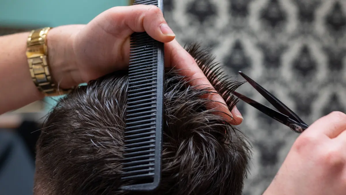 Ein Friseurin schneidet die Haare eines Kunden. Das Bundeskabinett will an diesem Mittwoch die geplante Erhöhung des Mindestlohns auf 12 Euro auf den Weg bringen. (zu dpa «Kabinett will 12 Euro Mindestlohn beschließen») +++ dpa-Bildfunk +++