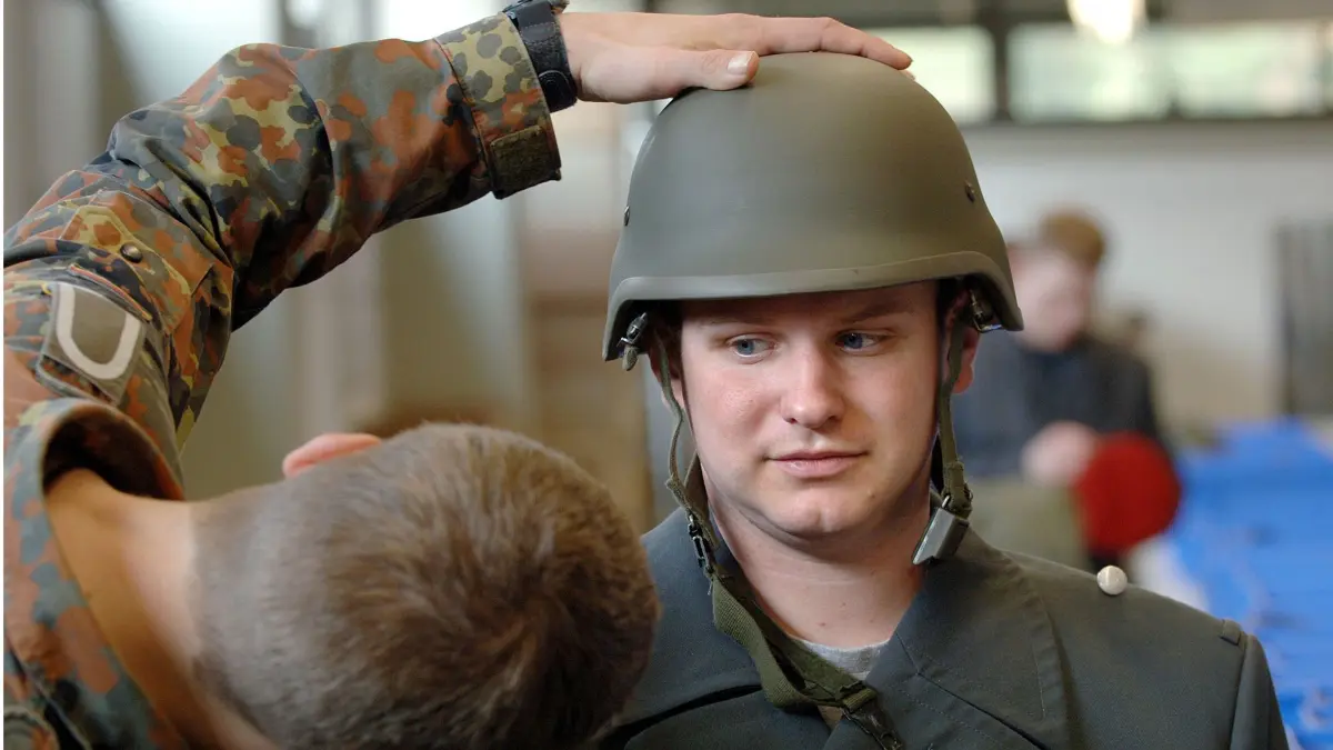 ARCHIV - Den richtigen Sitz des Helms überprüft ein Ausbilder bei einem Rekruten der Bundeswehr in der Generalfeldmarschall Rommel-Kaserne in Alsdorf (Archivfoto vom 05.04.2005). Nach mehr als 50 Jahren Wehrpflicht werden am Montag (03.01.2011) letztmals junge Männer regulär zum Dienst an der Waffe eingezogen. Im Rahmen der Bundeswehrreform wird die Wehrpflicht zum 1. Juli ausgesetzt. Foto: Oliver Berg (zu dpa 4261 vom 02.01.2011) +++(c) dpa - Bildfunk+++