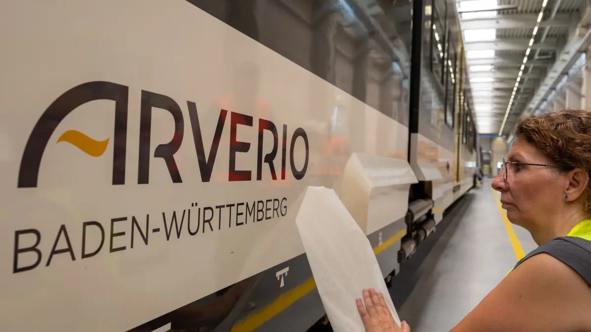 Eisenbahnunternehmen Go-Ahead wird zu Arverio: ACHTUNG: SPERRFRIST 10. JULI 13:00 UHR. - 08.07.2024, Bayern, Langweid: Im Betriebswerk foliert Isabella Deisser einen Triebwagen mit dem Schrifzug «Arverio Baden-Württemberg». Unter dem Namen Arverio werden künftig die bisherigen Züge von Go Ahead fahren. Seit 2024 ist die BB-Personenverkehr neue Alleingesellschafterin der Go-Ahead-Verkehrsgesellschaft Deutschland GmbH, zu der zwei Betriebsgesellschaften in Bayern und Baden-Württemberg gehören. Foto: Stefan Puchner/dpa +++ dpa-Bildfunk +++